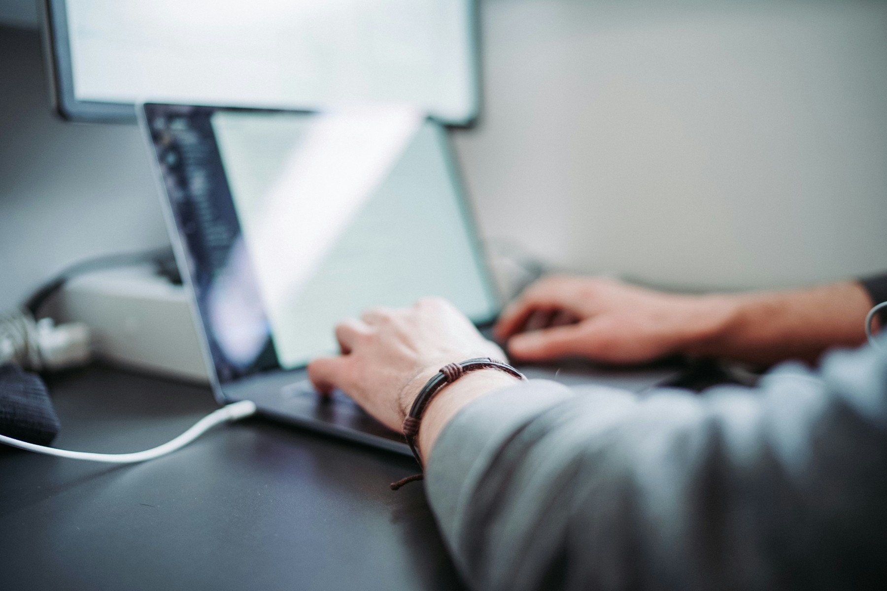 Close-up of hands typing on a laptop keyboard