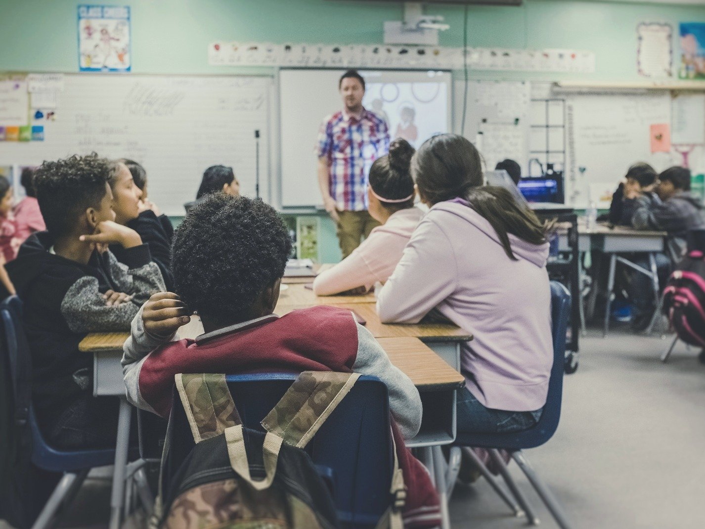 Students learning in a bright classroom with their teacher